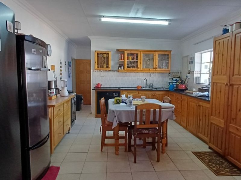 A functional kitchen featuring wooden cabinetry, tiled flooring, and a tiled backsplash, offering a traditional layout with ample storage space.