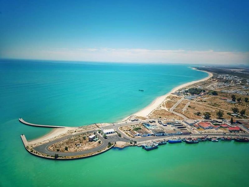 An aerial view of the coastal restaurant location, showcasing the surrounding harbour, beach, and local infrastructure.