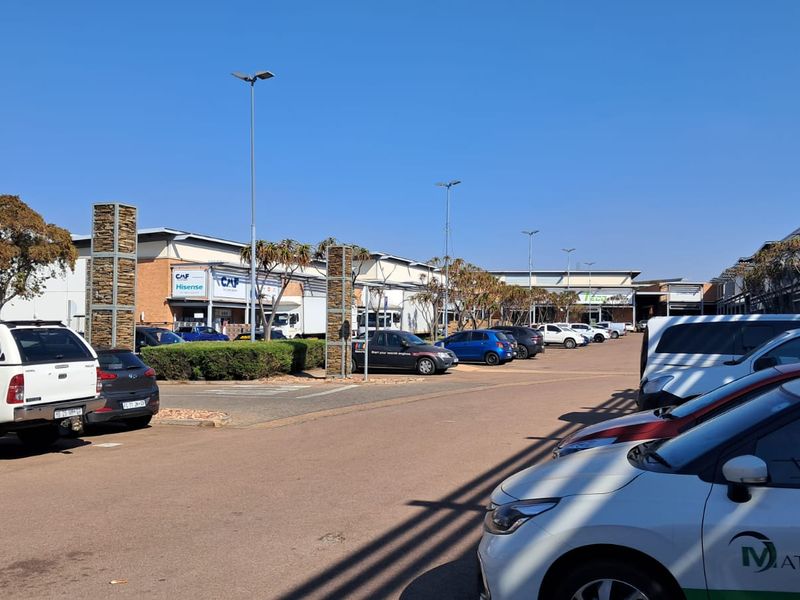 Exterior view of an industrial park complex featuring paved parking areas, modern building facades, and integrated street lighting.