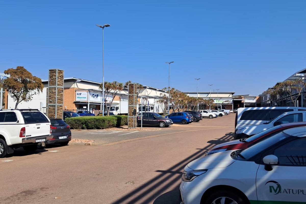 Exterior view of an industrial park complex featuring paved parking areas, modern building facades, and integrated street lighting.