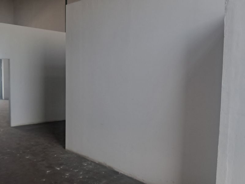An empty industrial utility space featuring concrete flooring and partition walls, suitable for storage or workshop use.