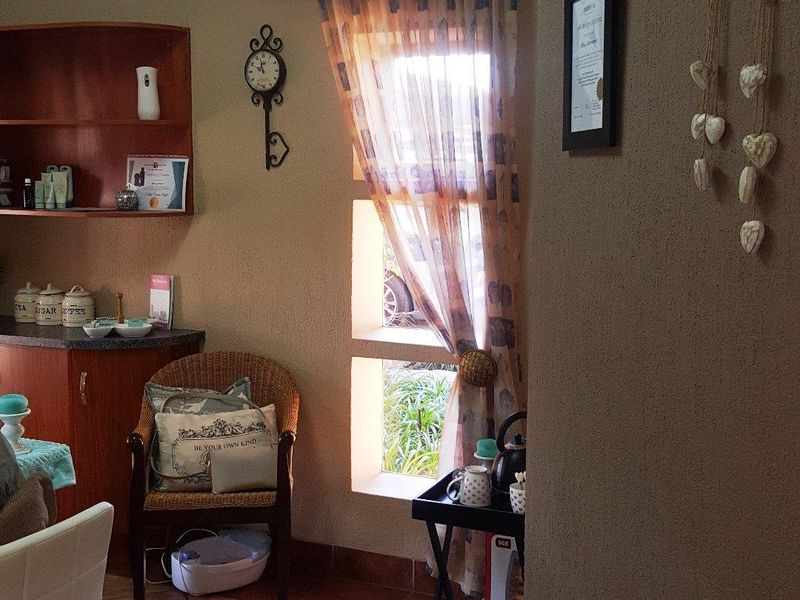 A functional utility space featuring tiled flooring, built-in cabinetry, and natural light from a side window.