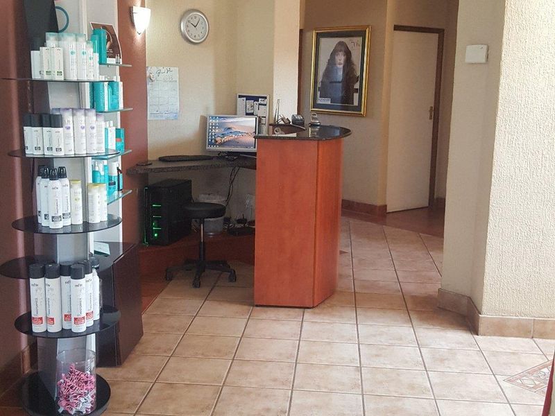 Commercial reception area featuring ceramic tiled flooring and a built-in reception desk, providing a functional entry point for clients.