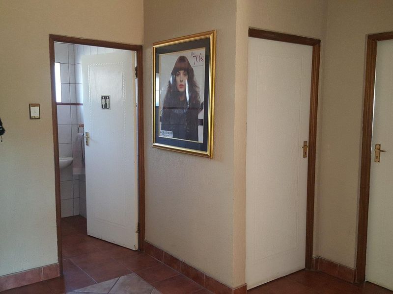 A functional hallway area featuring tiled flooring and multiple internal doors providing access to adjacent rooms.