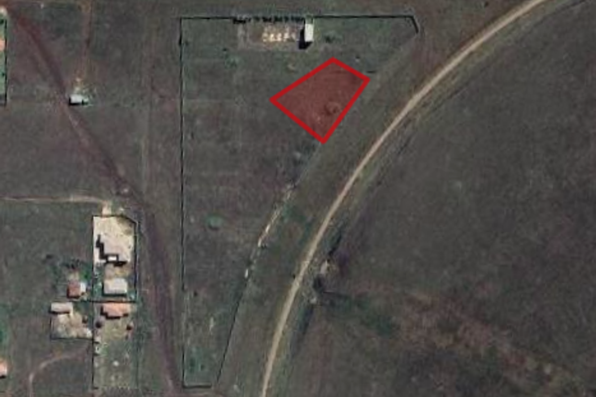 Aerial view of a vacant commercial land plot with boundary markings, situated in an open rural or semi-developed area.
