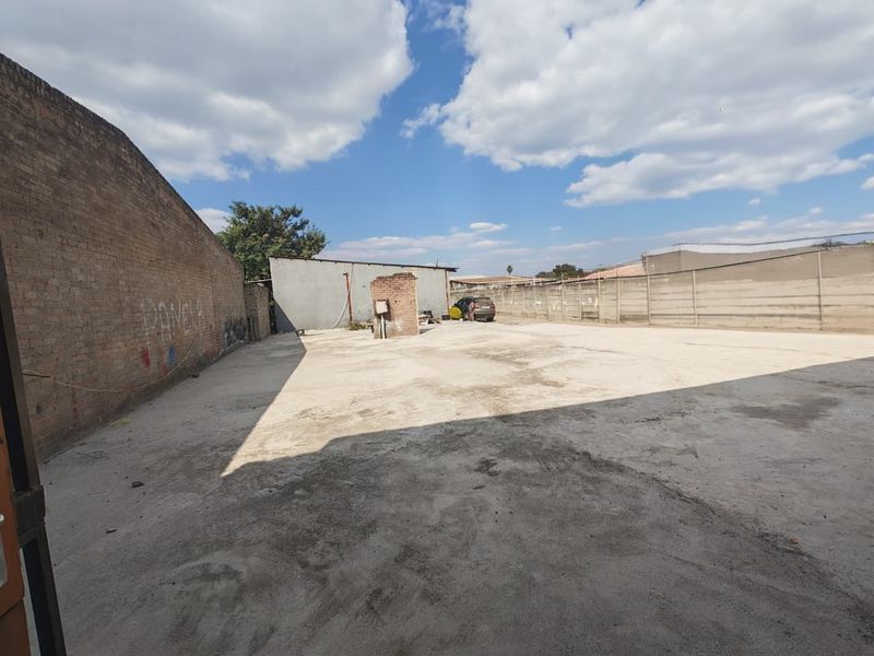 Spacious commercial concrete yard featuring high boundary walls, suitable for parking, storage, or industrial use.