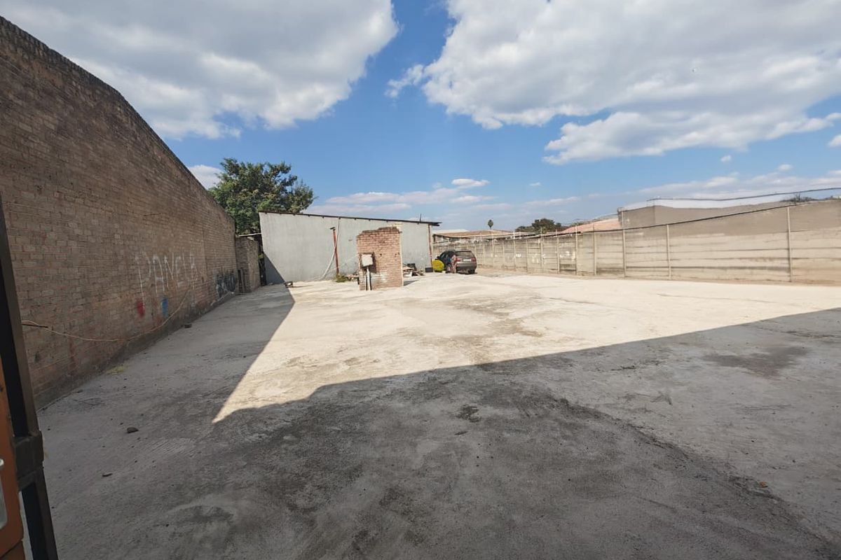Spacious commercial concrete yard featuring high boundary walls, suitable for parking, storage, or industrial use.