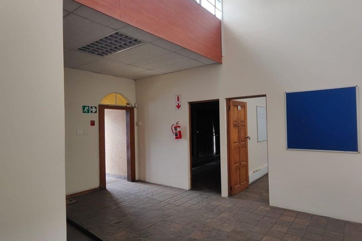 Spacious commercial entry area featuring high ceilings, clerestory windows for natural light, tiled flooring, and multiple access points.
