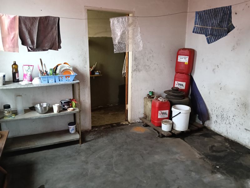 A utility space featuring concrete flooring and basic wall finishes, currently used for storage and general utility purposes.