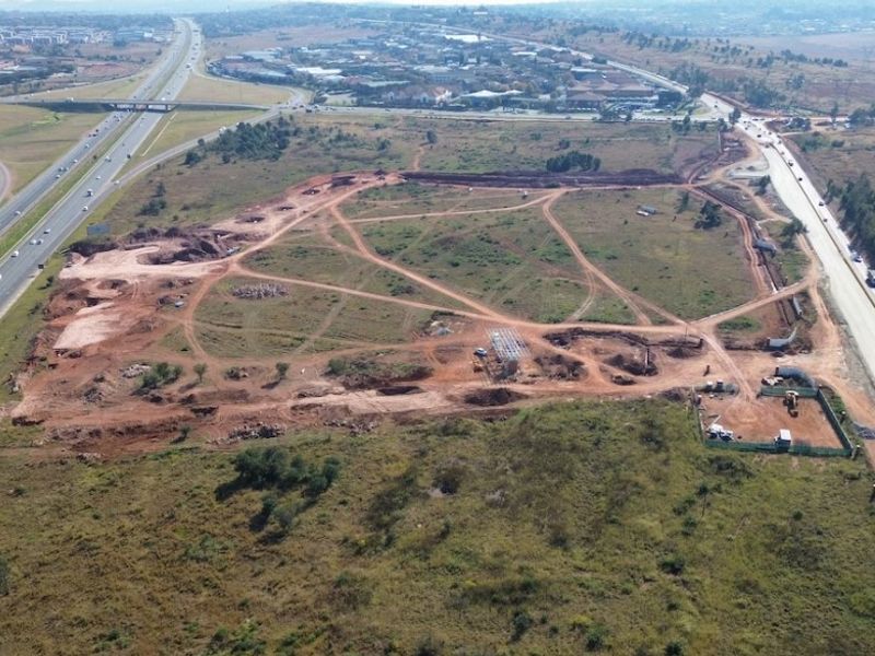 Aerial view of a large, undeveloped industrial land parcel situated adjacent to major highway infrastructure.