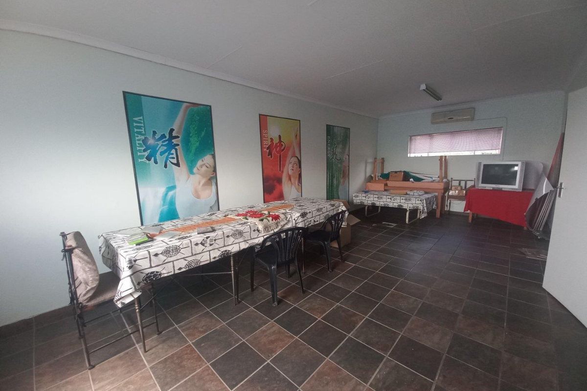 A functional commercial office space featuring tiled flooring, air conditioning, and neutral wall finishes, suitable for various business or professional uses.