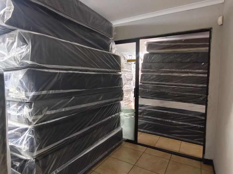 A utility or storage area featuring tiled flooring and a sliding glass door, currently utilized for bulk storage.