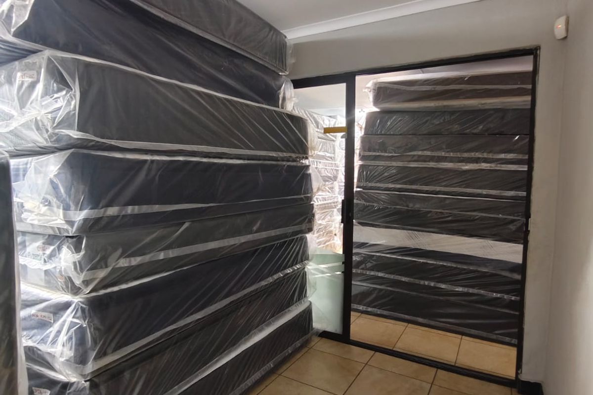 A utility or storage area featuring tiled flooring and a sliding glass door, currently utilized for bulk storage.