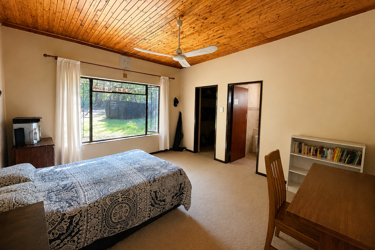 Spacious bedroom featuring a warm timber ceiling, ceiling fan, carpeted flooring, and direct access to an en-suite bathroom.