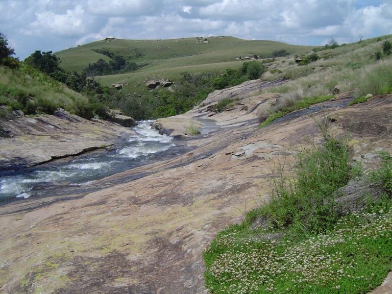 A scenic view of a natural stream flowing through a rocky landscape on the farm property.