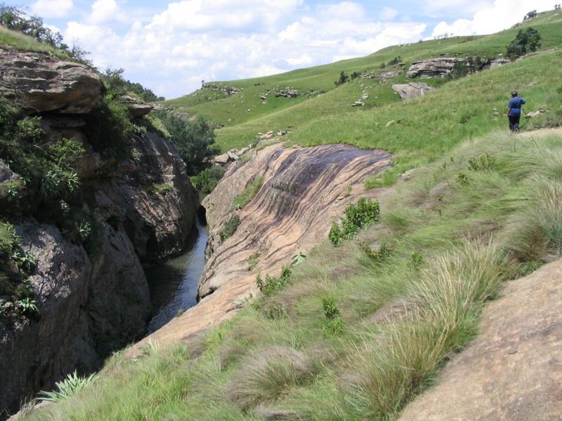 A scenic view of a natural stream flowing through a rocky gorge within the farm landscape.