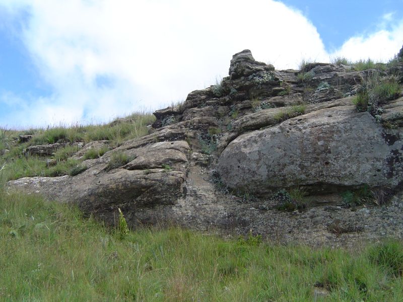 A natural landscape view featuring a prominent rock formation set within the property's open grassland terrain.
