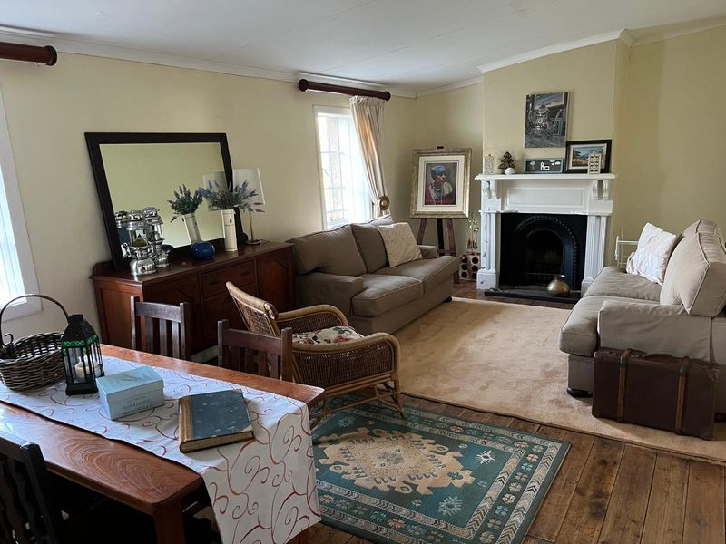 A cozy living room featuring a traditional fireplace with a white mantelpiece and warm timber flooring, creating a comfortable and inviting atmosphere.