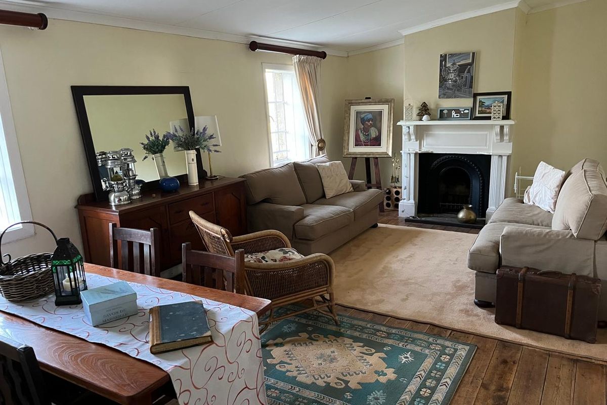 A cozy living room featuring a traditional fireplace with a white mantelpiece and warm timber flooring, creating a comfortable and inviting atmosphere.