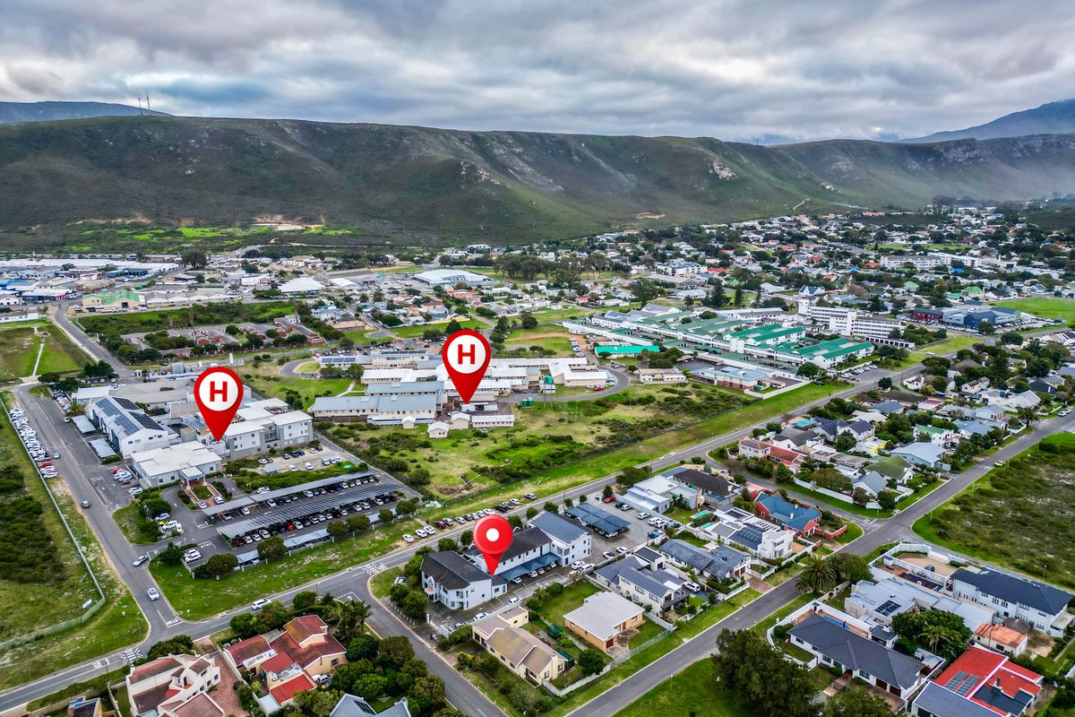 Aerial view of a commercial area featuring multiple building complexes, parking facilities, and surrounding residential infrastructure.