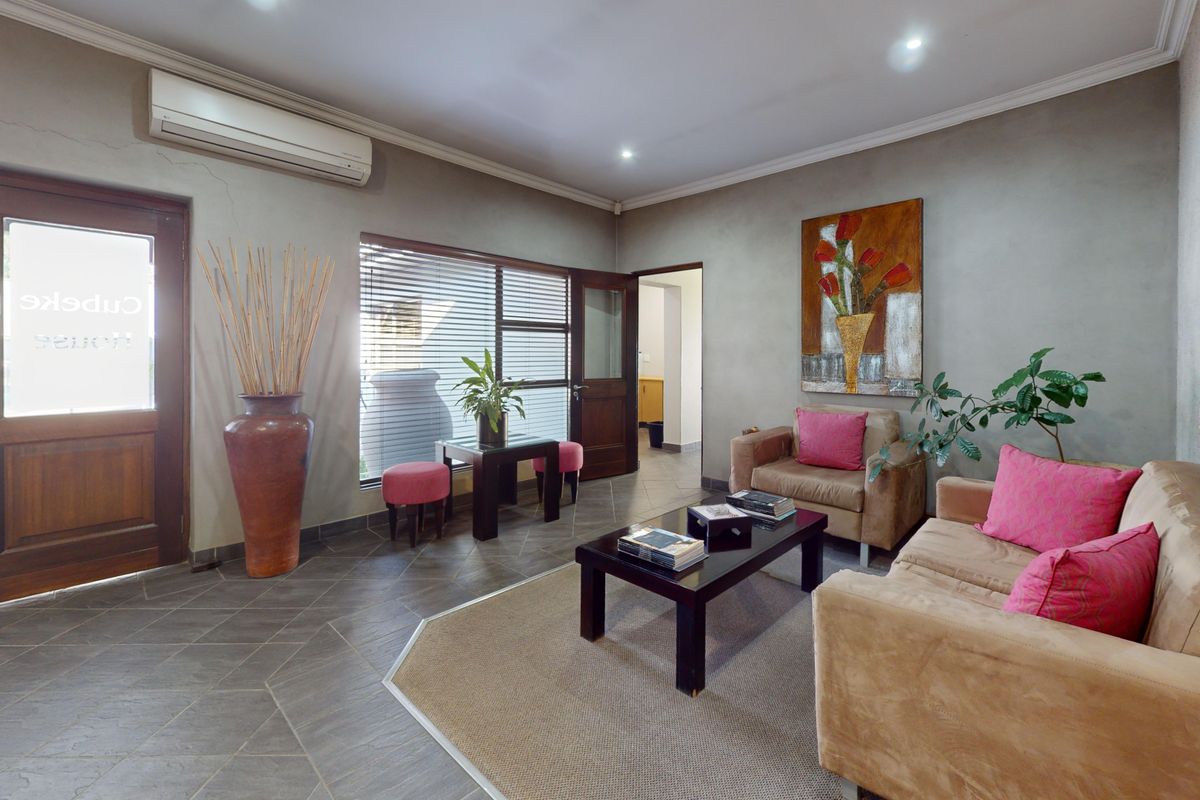 A commercial reception or waiting area featuring tiled flooring, recessed lighting, and a wall-mounted air conditioning unit.
