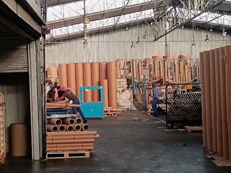 Spacious industrial warehouse facility featuring high-bay lighting, exposed steel truss roofing, and durable concrete flooring, suitable for manufacturing or large-scale storage operations.