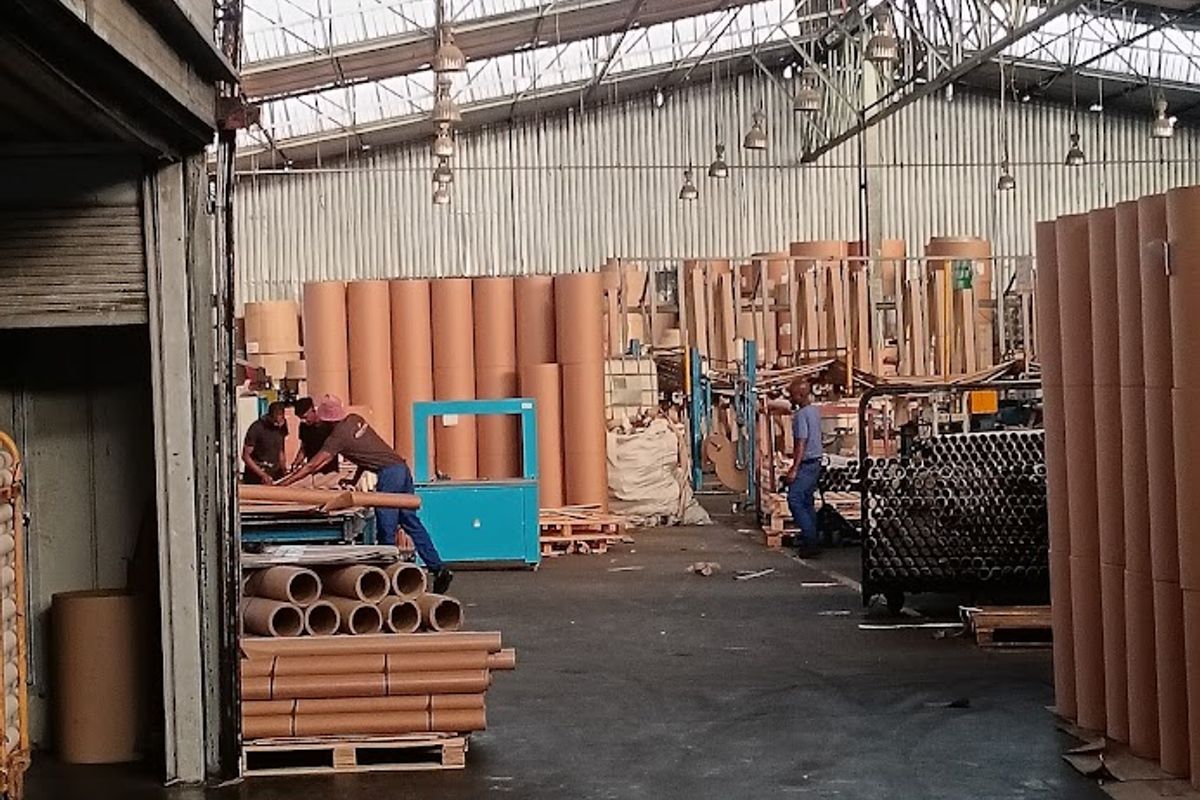 Spacious industrial warehouse facility featuring high-bay lighting, exposed steel truss roofing, and durable concrete flooring, suitable for manufacturing or large-scale storage operations.