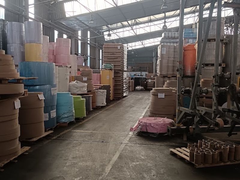 Spacious industrial warehouse facility featuring high-clearance steel truss roofing, concrete flooring, and integrated skylights, suitable for manufacturing or large-scale storage operations.