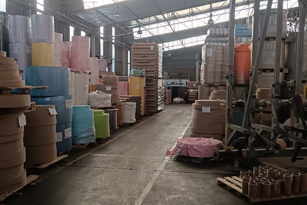 Spacious industrial warehouse facility featuring high-clearance steel truss roofing, concrete flooring, and integrated skylights, suitable for manufacturing or large-scale storage operations.