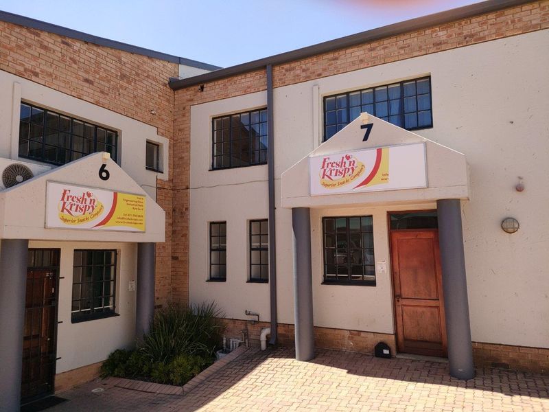 Exterior view of industrial units 6 and 7, featuring brick and plaster facade, covered entrances with columns, and multi-pane windows.