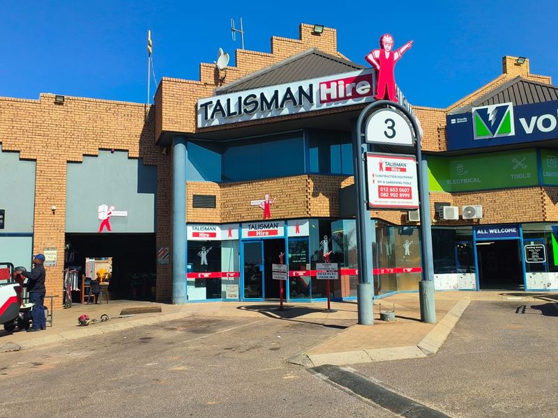 Front elevation of a commercial retail property featuring brick construction, glass storefronts, and prominent signage for multiple tenants.