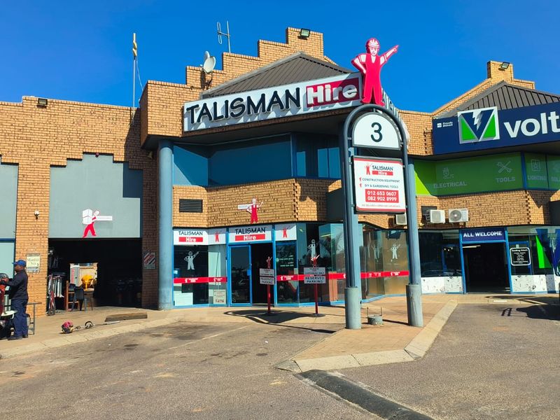 Front exterior view of a commercial retail building featuring brick construction, glass storefronts, and prominent signage for multiple tenants.