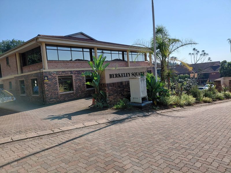 Front exterior view of Berkeley Square office building featuring brick facade, tinted windows, and paved driveway access.