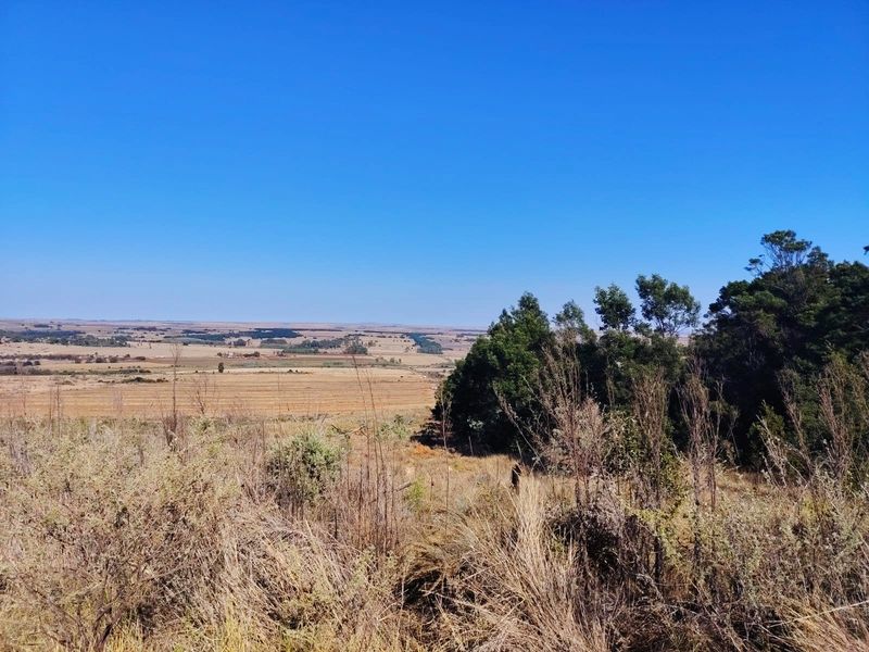 Expansive panoramic view of the surrounding rural landscape and farmland, showcasing the open terrain and natural vegetation of the property.