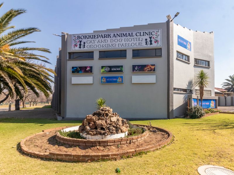 Front exterior view of the Bokkiepark Animal Clinic building, featuring prominent signage, a landscaped garden bed, and paved access areas.