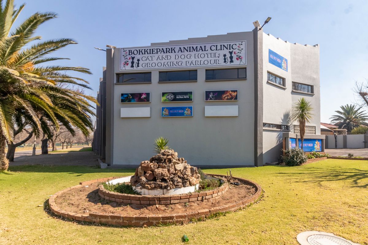 Front exterior view of the Bokkiepark Animal Clinic building, featuring prominent signage, a landscaped garden bed, and paved access areas.