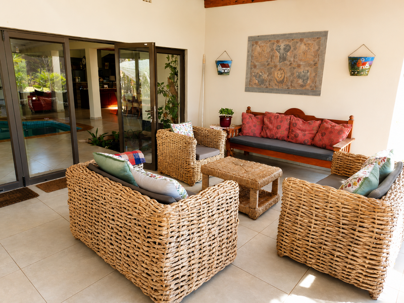 A covered patio area featuring tiled flooring and large aluminium sliding doors that provide direct access to the indoor living space and pool area.