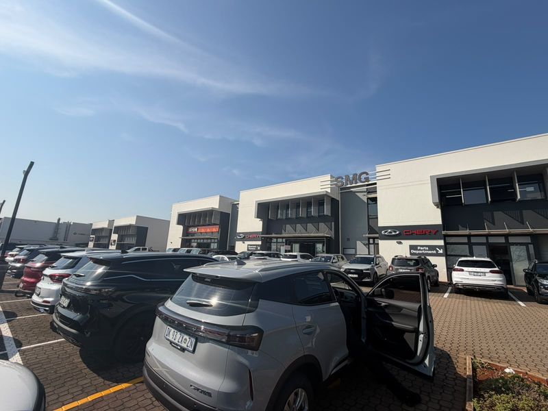 Front exterior view of a commercial retail property featuring a paved parking lot and modern building facade with signage.