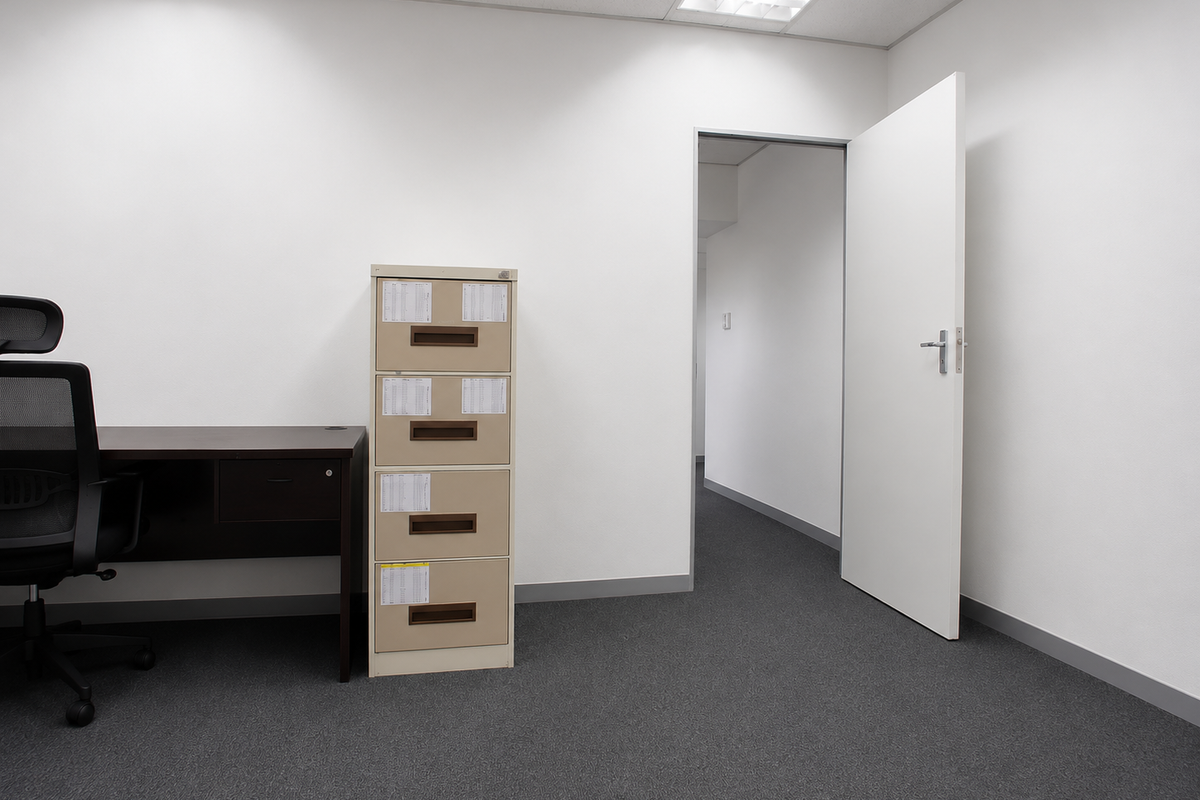 A clean, professional office space featuring neutral walls, grey carpeting, and recessed ceiling lighting, providing a functional environment for business operations.