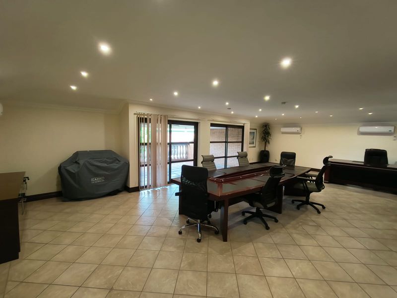 Spacious office area featuring ceramic tile flooring, recessed lighting, dual split-system air conditioning units, and large sliding glass doors providing access to the exterior.