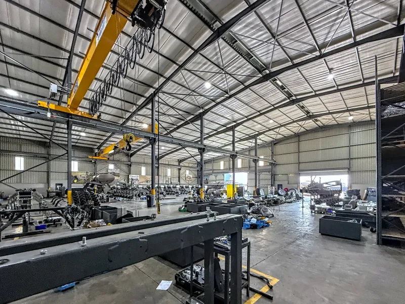 Spacious industrial warehouse featuring a high-clearance steel portal frame, overhead gantry crane system, durable concrete flooring, and efficient high-bay lighting.