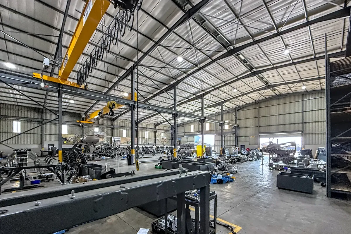 Spacious industrial warehouse featuring a high-clearance steel portal frame, overhead gantry crane system, durable concrete flooring, and efficient high-bay lighting.