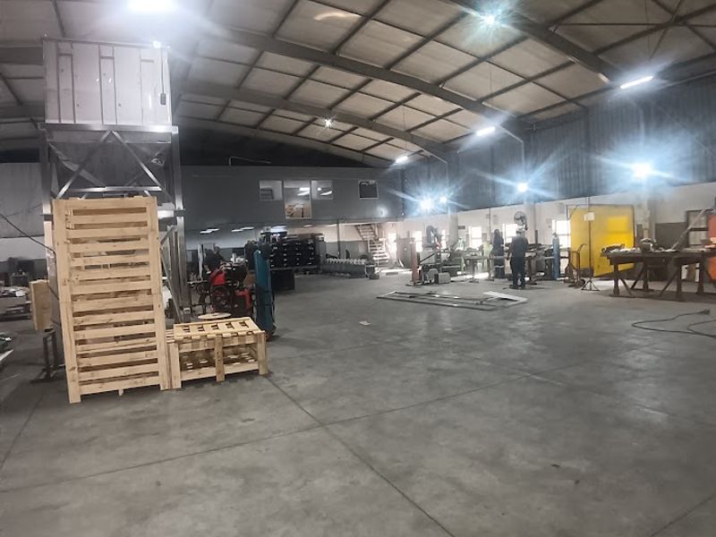 Spacious industrial warehouse featuring high ceilings, concrete flooring, and a mezzanine level, suitable for manufacturing or storage operations.
