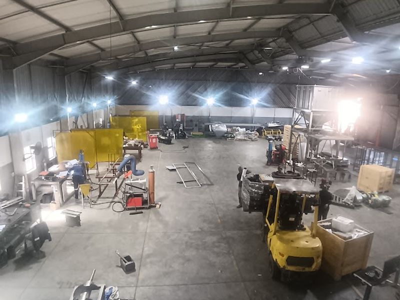 Spacious industrial warehouse facility featuring high-bay lighting, durable concrete flooring, and a robust steel portal frame structure suitable for manufacturing or storage operations.