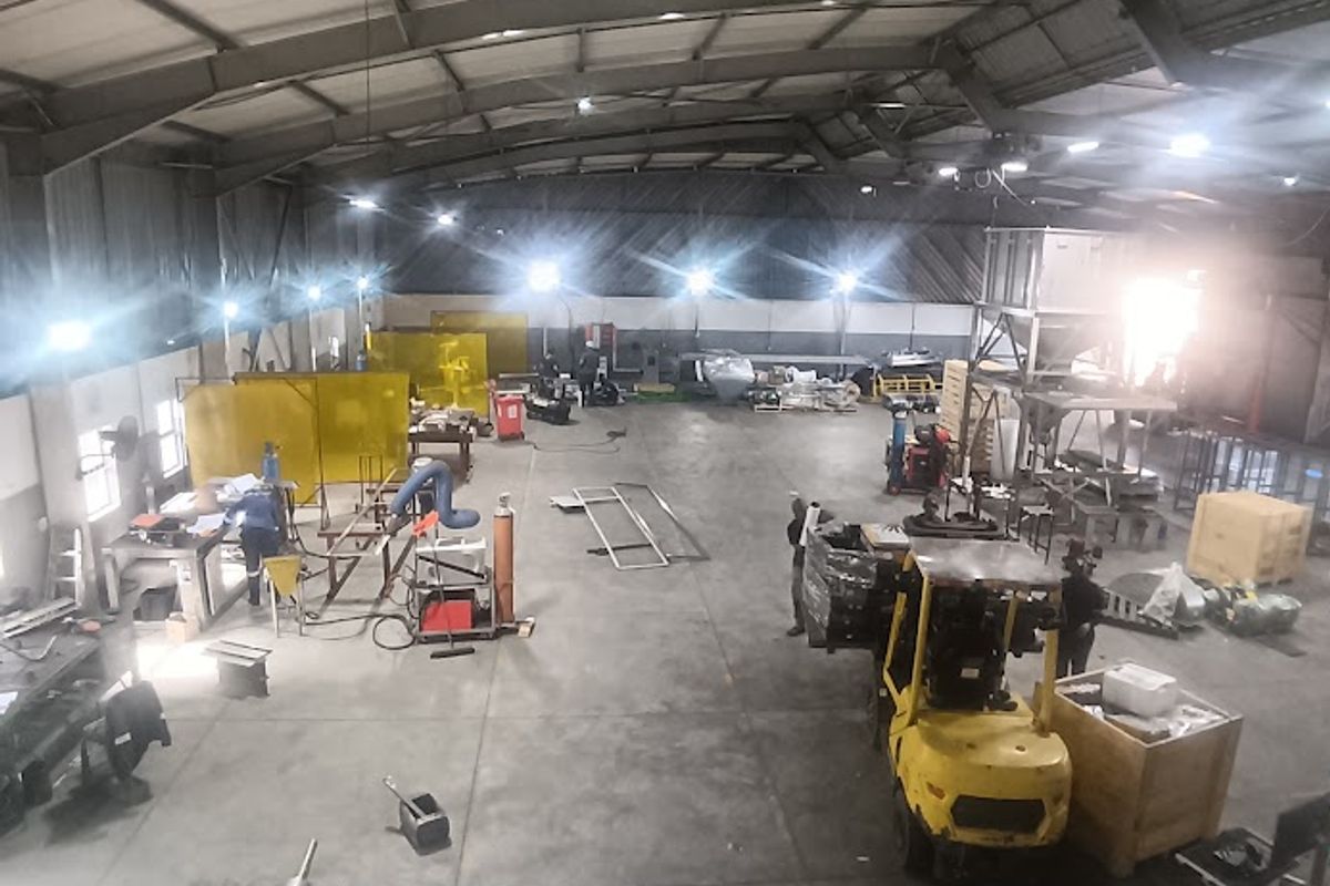 Spacious industrial warehouse facility featuring high-bay lighting, durable concrete flooring, and a robust steel portal frame structure suitable for manufacturing or storage operations.