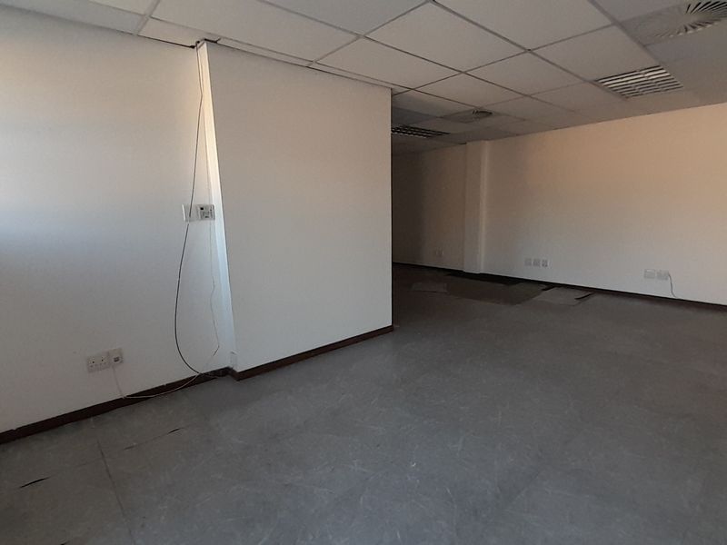 An empty, open-plan office space featuring a suspended ceiling, recessed air conditioning, and neutral vinyl flooring, ready for custom fit-out.