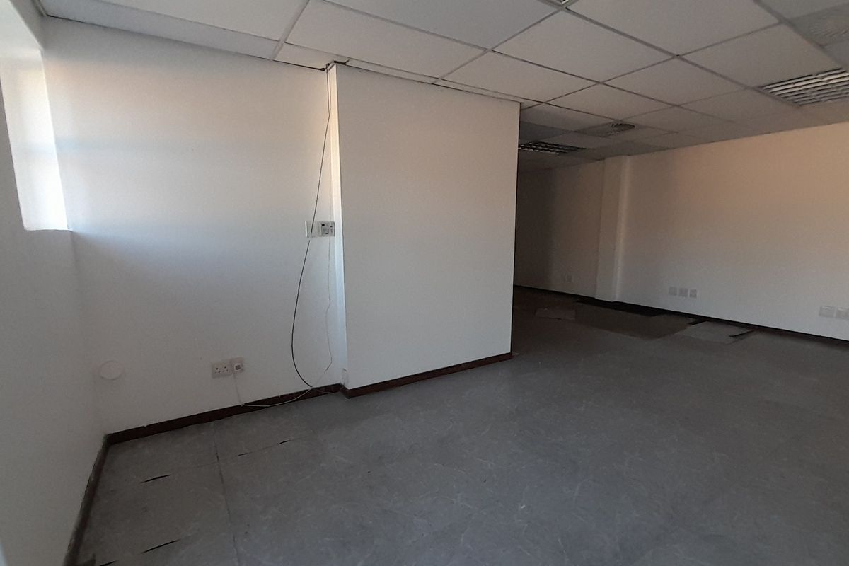 An empty office space featuring a suspended ceiling, recessed lighting, and tiled flooring, ready for custom fit-out and configuration.
