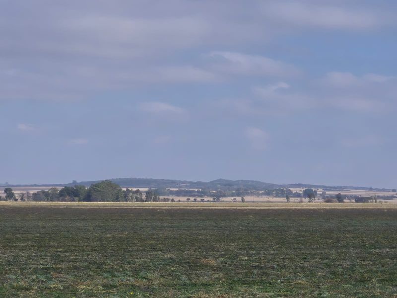 A wide-angle view of the expansive rural landscape and open fields surrounding the property.