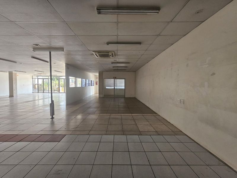 Spacious open-plan retail area featuring ceramic tile flooring, suspended ceiling with integrated lighting, and air conditioning, ready for custom fit-out.