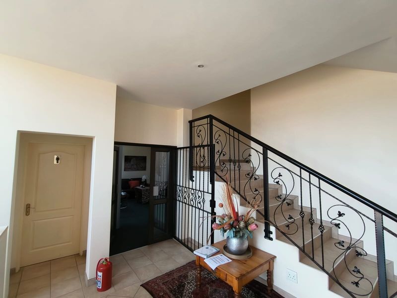 Entrance area featuring a tiled staircase with decorative wrought iron balustrades and a secure gated access point.